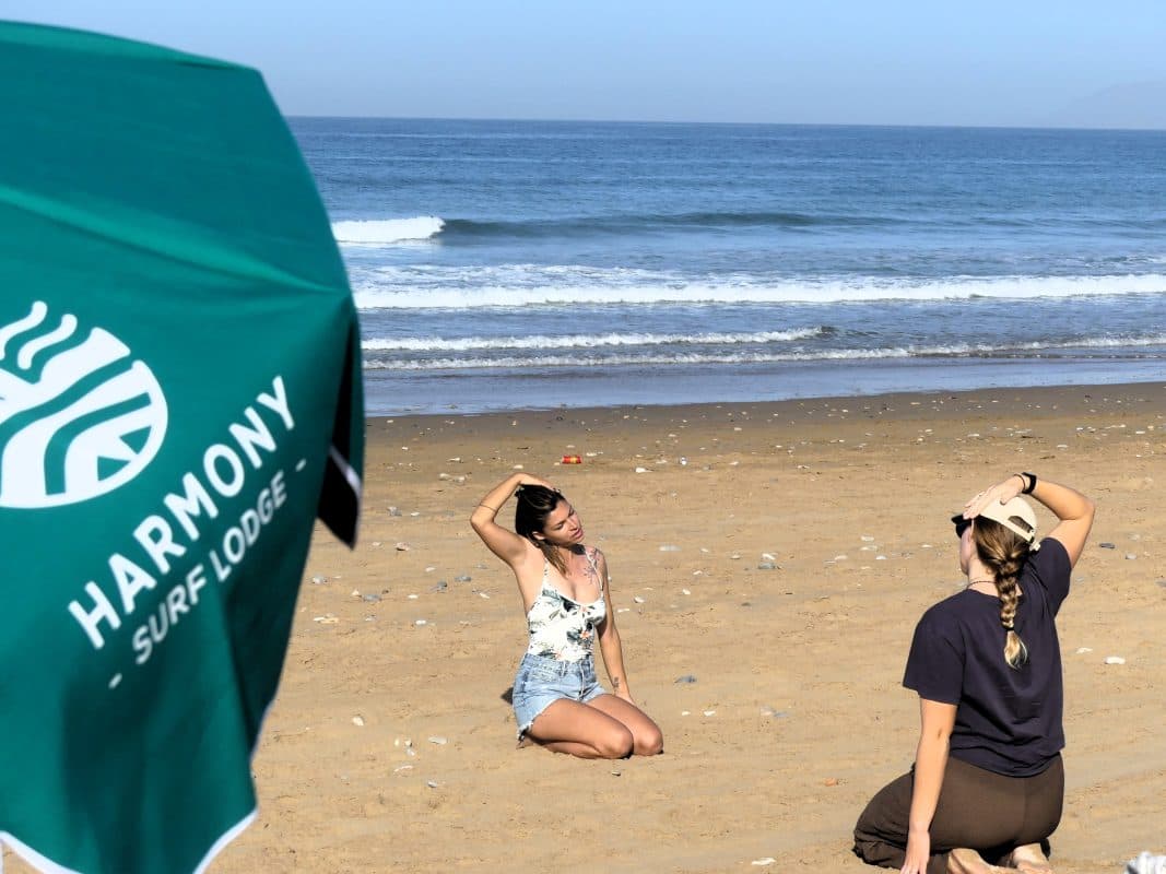 Guests relaxing on the beach under the Harmony parasol