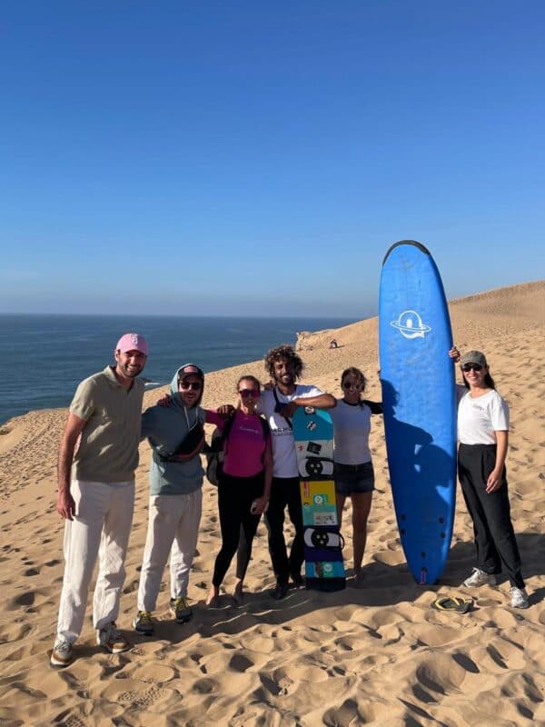 Guests and coaches on the dunes above the beach