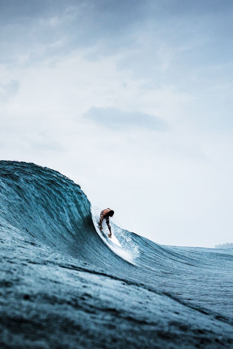 A surfer dropping into a clean wall