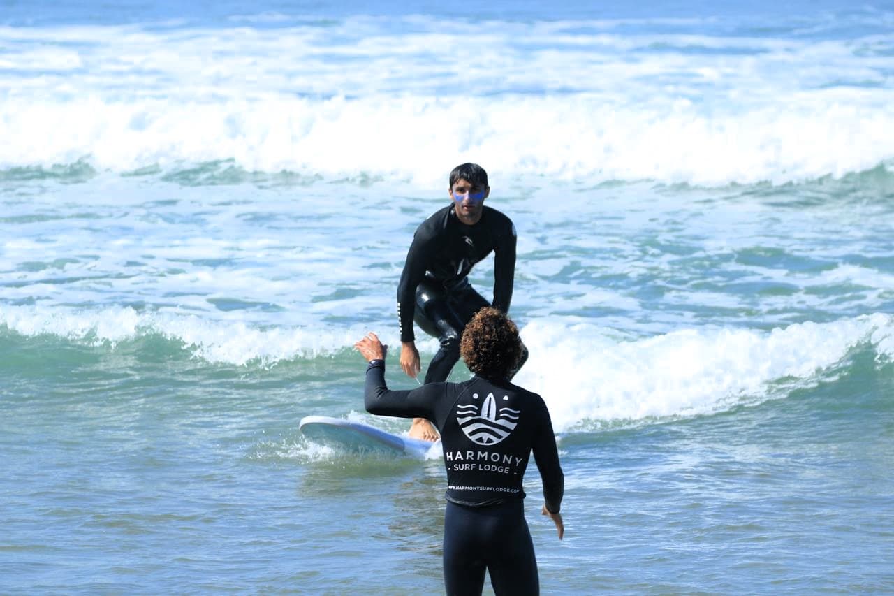 A coach pushing a student into a wave